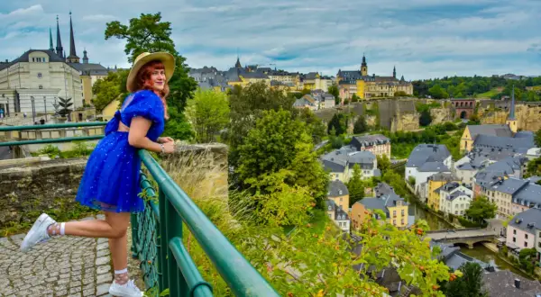 Kobieta w niebieskiej sukience podziwia panoramę Luksemburga. Warto zobaczyć to miasto pełne urokliwych uliczek i zabytków.