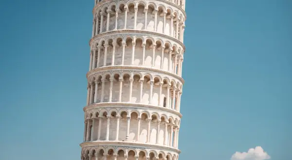 La Torre di Pisa, con la sua inconfondibile pendenza, si erge maestosa sotto un cielo azzurro.