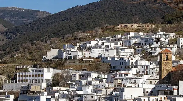Pueblo blanco en ladera montañosa, ideal para saber qué ver en Almería capital. Destaca su torre campanario.