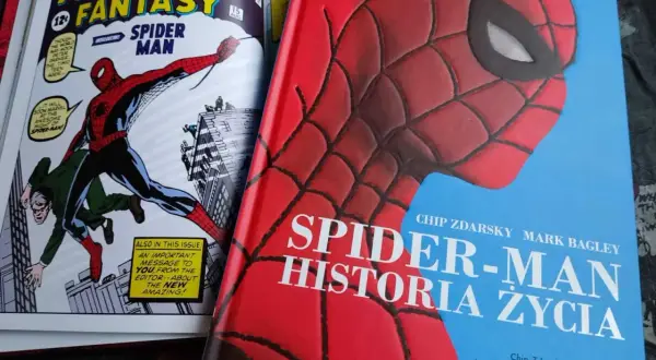 Okładka książki "Spider-Man: Historia Życia" z wizerunkiem Spider-Mana. Obok komiks "Amazing Fantasy" z pierwszym pojawieniem się bohatera.