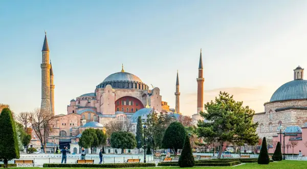 Majestatyczna Hagia Sophia w Stambule, z jej kopułą i minaretami, góruje nad zielonym parkiem.