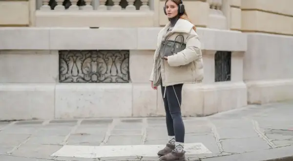 Modna dziewczyna w słuchawkach prezentuje stylowe stylizacje ze skarpetkami, które dodają charakteru jej zimowemu outfitowi.