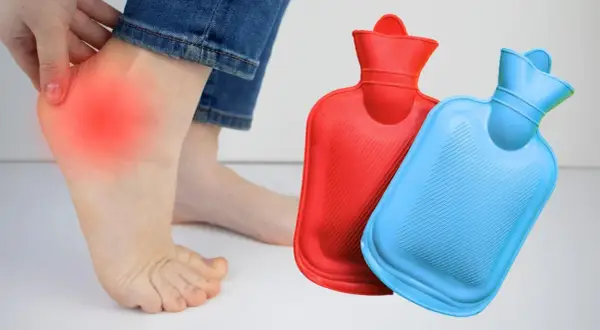 Fuß mit rotem Schmerzbereich am Hacken, daneben zwei Wärmflaschen in Rot und Blau.