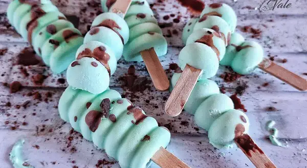 Deliziosi gelati alla menta con gocce di cioccolato, pronti per essere gustati su un bastoncino di legno.