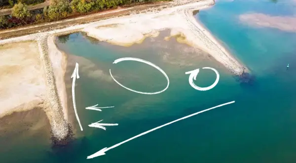 Luftaufnahme einer Sandbank in der Elbe mit weißen Pfeilen und Kreisen, die Strömungen oder Angelplätze markieren.