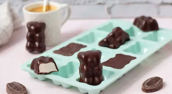 Délicieux oursons en guimauve recette, enrobés de chocolat noir, prêts à être dégustés. Une gourmandise maison.