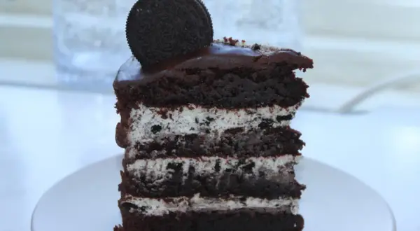 En bit chokladkaka med lager av krämig fyllning och krossade oreos. En hel oreo kex toppar denna läckra oreo tårta.