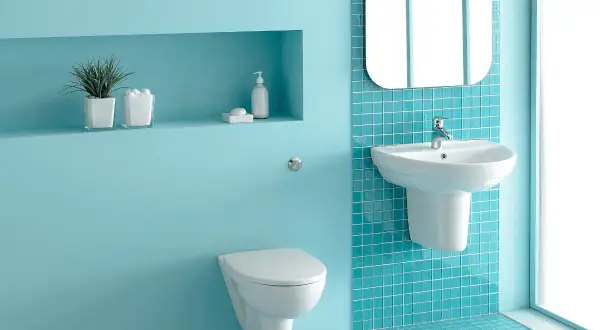 Un moderno bagno verde acqua e bianco con sanitari sospesi, lavabo e specchio.