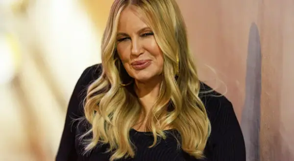 Jennifer Coolidge, znana jako mama Stiflera, z charakterystycznym uśmiechem i blond włosami.