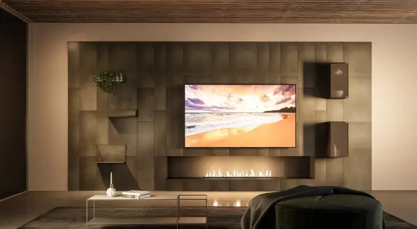Un salon moderne avec une cheminée éthanol, une TV affichant une plage et une **déco derrière télé** minimaliste avec des étagères et une plante.