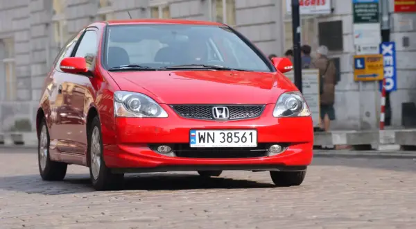 Czerwony Honda Civic VII, gotowy do wymiany żarówki mijania.