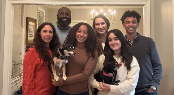 La familia anfitriona posa sonriente con sus dos perros.