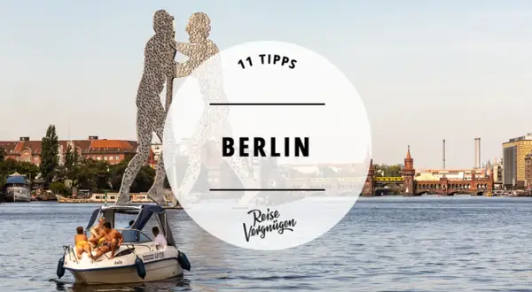11 Tipps für Ihren Besuch in Berlin: Eine Bootsfahrt auf der Spree mit Blick auf die Oberbaumbrücke und die Skulptur "Molekularmensch".