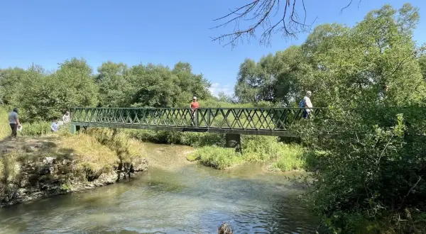 Ludzie na moście nad rzeką, odkrywający malownicze słowacki raj trasy.