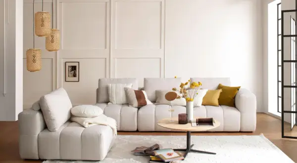 Helles Wohnzimmer mit beigem Sofa, Korb-Pendelleuchten und einem runden Couchtisch. Die Einrichtung folgt Feng Shui Regeln für Harmonie.