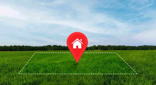 Un terreno verde con un marcador rojo de casa en el centro. Ideal para tu hipoteca para comprar terreno y construir tu hogar soñado.