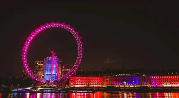 Londyn nocą: London Eye i oświetlone budynki nad Tamizą. Te **anglia zabytki** lśnią w kolorach, tworząc magiczny widok.