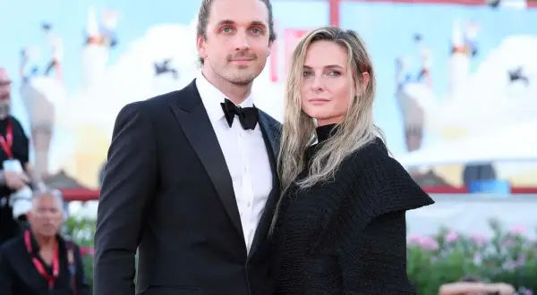 Rory St. Clair Gainer y su pareja posan en la alfombra roja. Él, con esmoquin, y ella, con un elegante vestido negro.