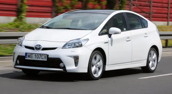 Biały Toyota Prius 3 na drodze, z widocznym numerem rejestracyjnym WE 107CV.