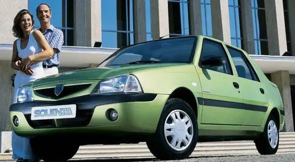 Szczęśliwa para obok zielonej Dacii Solenza. Wyobraź sobie podróż w 2026 roku tym niezawodnym autem.