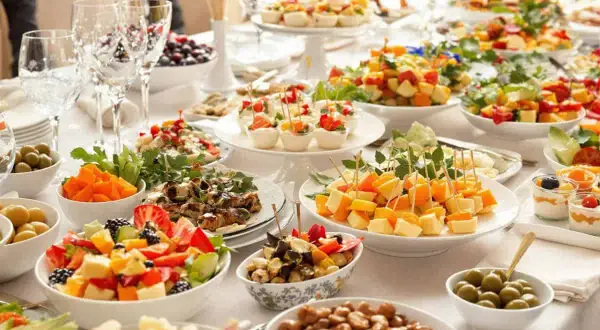 Un aperitif dinatoire que faire ? Une table garnie de salades de fruits, brochettes de fromage, olives, et autres délices pour un repas convivial.