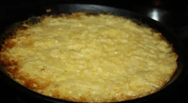 En gyllene potatiskaka med parmesan, nybakad i gjutjärnspanna. Låter det inte gott?