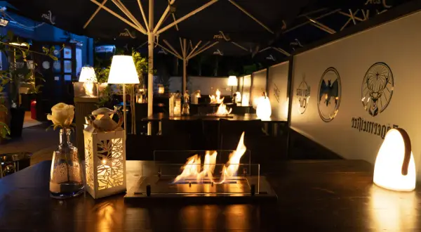 Gemütliche Atmosphäre mit Feuerstelle und Beleuchtung auf der Terrasse. Perfekt für Veranstaltungen in Bergisch Gladbach.