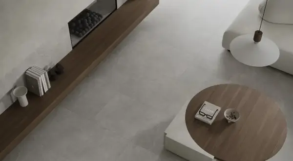 Nowoczesny salon z kominkiem i meblami. Podłoga z płytek imitujących kamień, czyli terakota, co to za materiał?