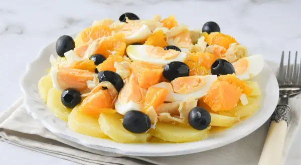 Ensalada malagueña con patatas, naranja, huevo duro, bacalao desmigado y aceitunas negras.