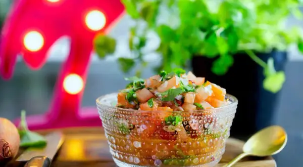 En skål med färsk salsa, perfekt för ditt nästa salsa recept. Tomater, lök och koriander i en vacker glasburk.