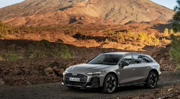 Szary Audi allroad na tle wulkanicznego krajobrazu z górami w tle.
