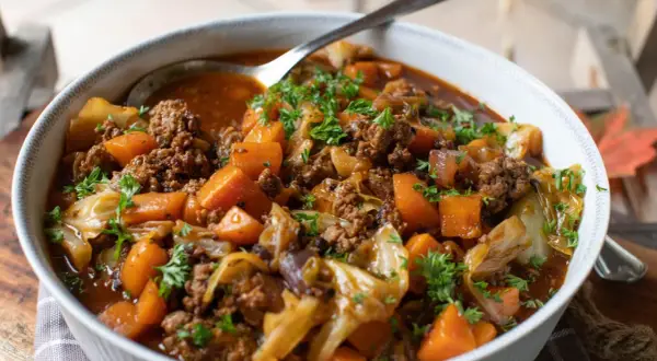 Herzhaftes One-Pot-Gericht mit Hackfleisch, Süßkartoffeln und Kohl, garniert mit Petersilie. Perfekt für kalte Tage.