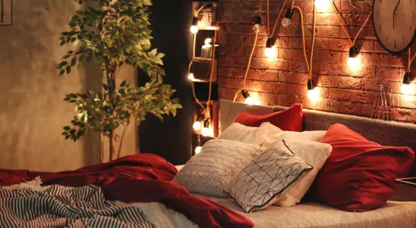 Atmosfera accogliente con luci soffuse e cuscini morbidi: ecco delle idee camera da letto per un relax totale.