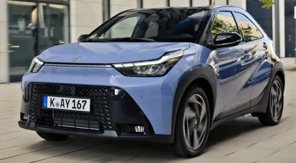 Niebieskie Toyota Aygo X w ruchu. Sprawdź atrakcyjną toyota aygo x cena i wyposażenie.