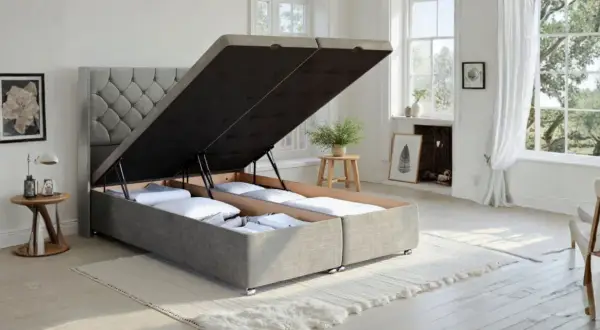 A divan bed with its storage compartments open, revealing neatly folded linens. This versatile divan offers ample hidden storage.