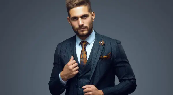 Stilvoller Mann im Anzug mit gemustertem Hemd, Krawatte und Einstecktuch. Perfekt, um sich ein Outfit zusammenstellen zu lassen.