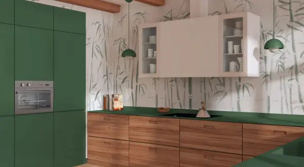 Nowoczesna kuchnia z zielonymi frontami i drewnianymi szufladami. Ściany zdobi subtelna tapeta z motywem bambusa.