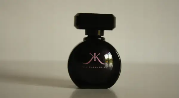 Czarna butelka perfum Kim Kardashian z różowym logo.