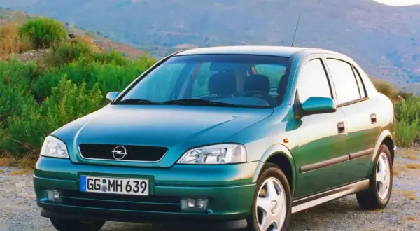 Zielony Opel Astra Classic 1999 na tle górskiego krajobrazu.