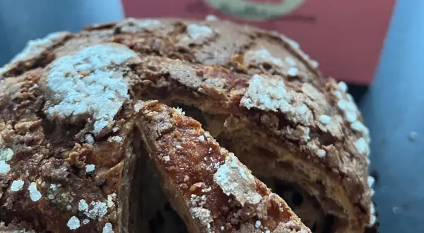 Un delicioso panettone con trozos de chocolate, listo para ser disfrutado. Así se come el panettone, en rebanadas esponjosas.