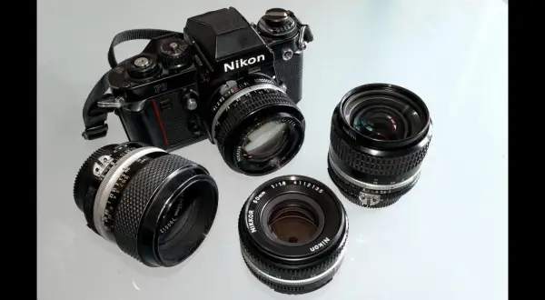 Stary aparat fotograficzny na klisze Nikon F3 z kilkoma obiektywami Nikkor.