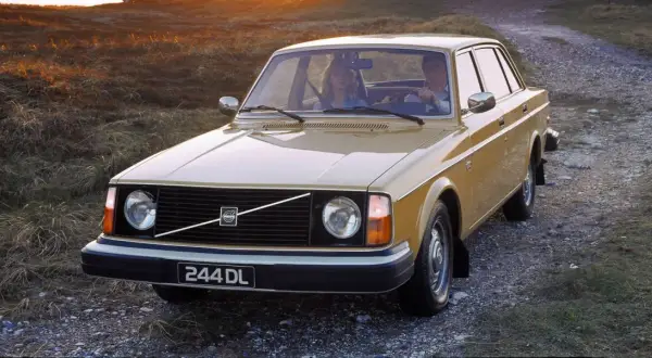 En gul Volvo 244 DL kör på en grusväg i solnedgången. Hur många Volvo 240 tillverkades? Över 2,8 miljoner.