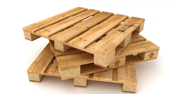 Empilement de palettes en bois brut, prêtes à être poncées pour un nouveau projet.
