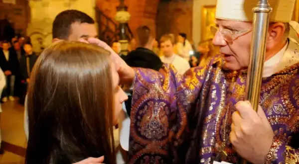 Biskup udziela sakramentu bierzmowania. Ceremonia trwa krótko, ale jest pełna duchowego znaczenia.
