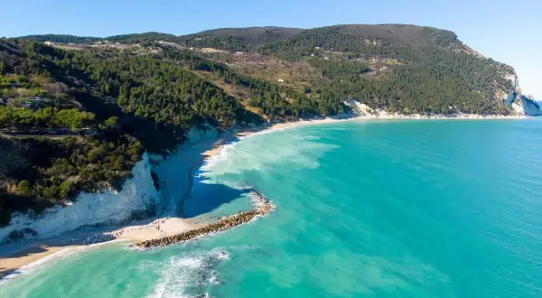 Spiaggia di Numana con scogliere bianche, mare turchese e pineta. Ecco cosa vedere a Numana per un panorama mozzafiato.