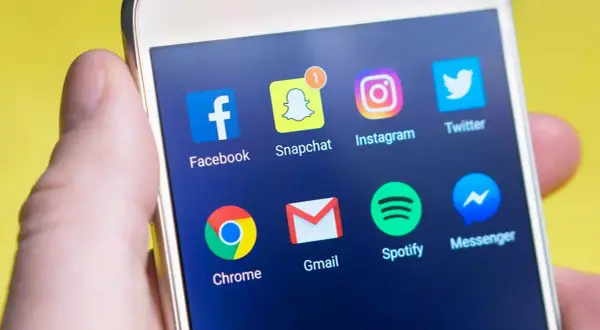 Ekran smartfona z ikonami aplikacji: Facebook, Snapchat, Instagram, Twitter, Chrome, Gmail, Spotify, Messenger. Dowiedz się, jak wyłączyć dostępność na Messengerze.