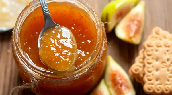 Marmellata di fichi con la buccia, gustosa e profumata, pronta per essere spalmata su biscotti croccanti.