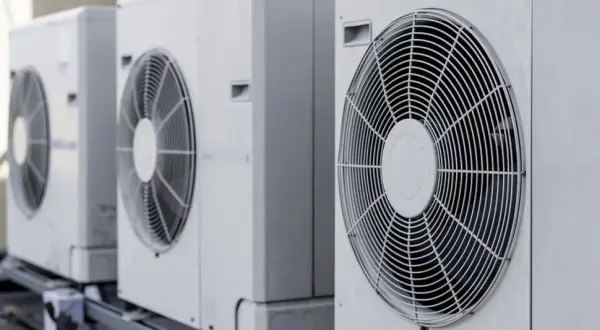 Rząd białych jednostek zewnętrznych, gdzie pompa ciepła i klimatyzacja pracują razem, zapewniając komfort.