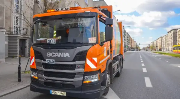 Pomarańczowy śmieciarka Scania na ulicy w Warszawie. Zakaz wjazdu tirów w centrum miasta nie dotyczy pojazdów komunalnych.