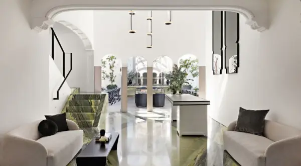 A modern living space with green marble floors and a striking staircase, feeling chic by accident in Mexico City.